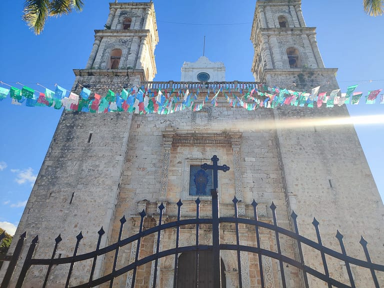 Image of a church, taken looking upward to the top of the building. In front of the church are colourful streamers